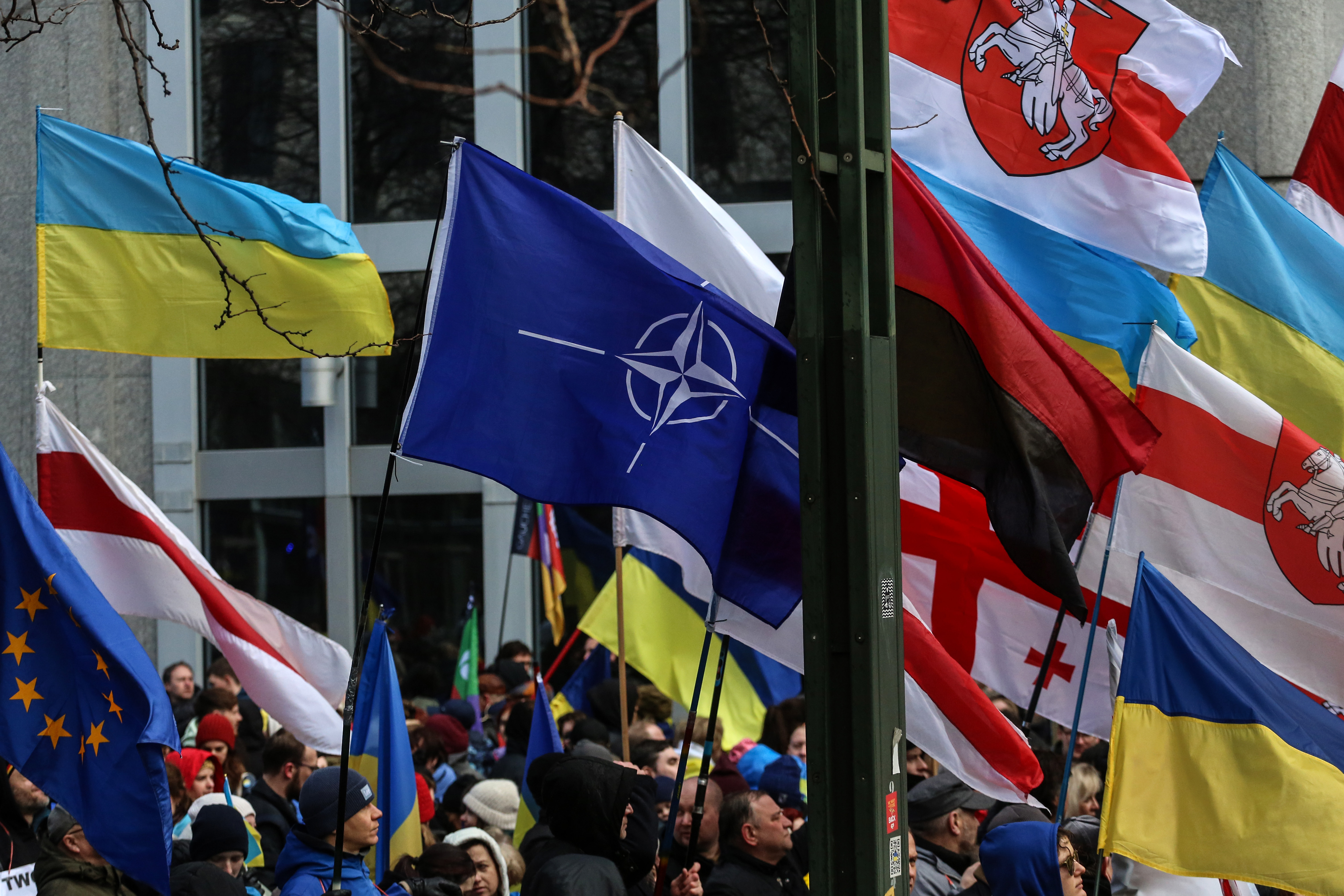 Un drapeau de l'OTAN flotte au milieu de drapeau Ukrainien lors d'une manifestation en Belgique en février 2023. / © Valeria Mongelli by Hans Lucas.