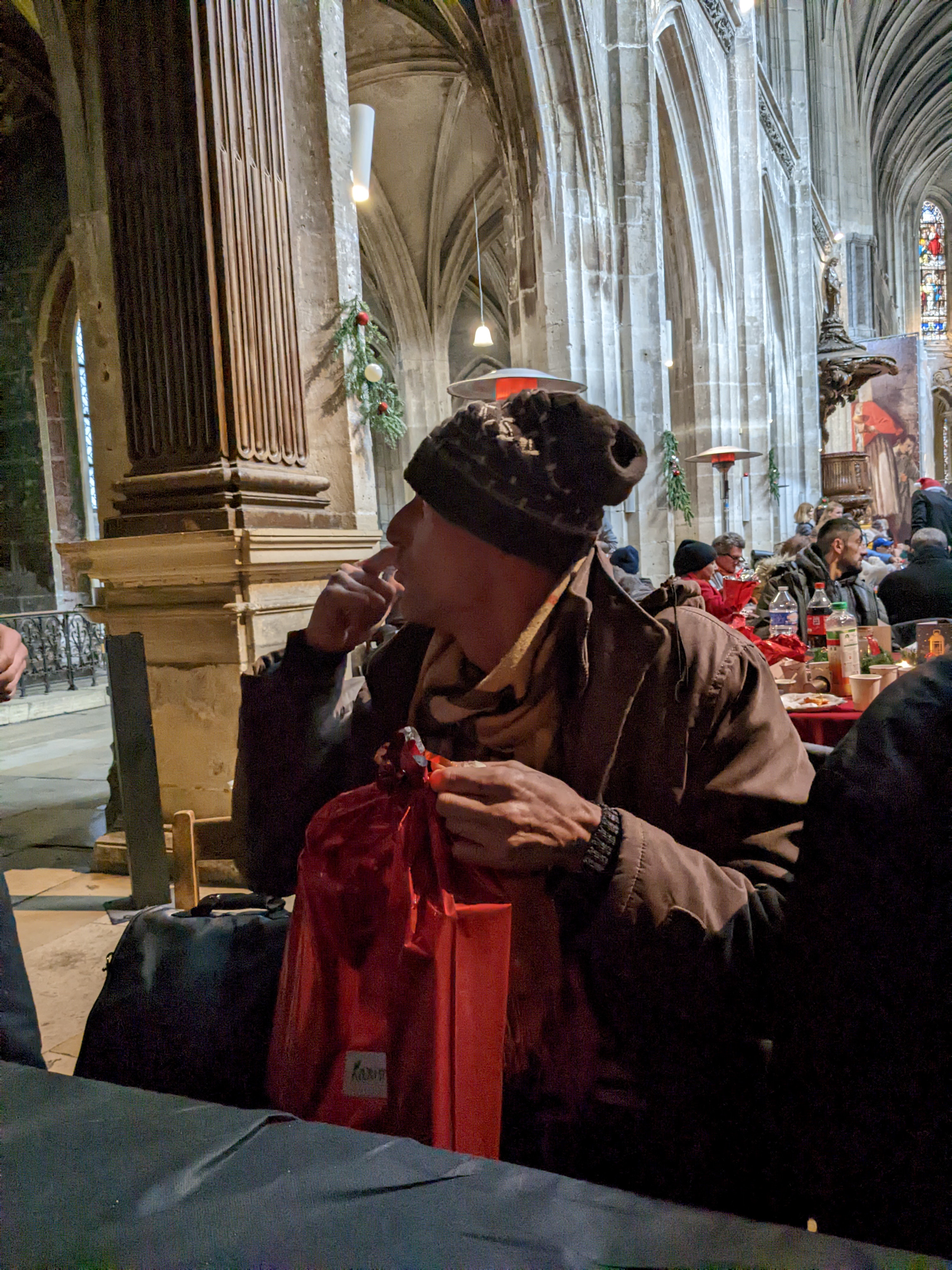 Nabil, quelques secondes avant d'arracher son paquet cadeau pendant le repas de Noël organisé par la communauté Sant'Egidio/ Amélie Gazeau
