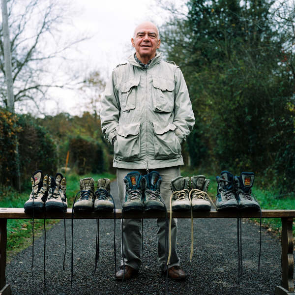 Bernard Ollivier devant ses multiples chaussures de randonnée / Bernard Ollivier