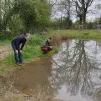 Jérôme Bertrand et Dorian Angot, du CPIE Loire-Anjou, et Hugo Coutand, qui a créé cette mare avec son père en 2013, scrutent l'eau à la recherche d'amphibiens. ©RCF Anjou