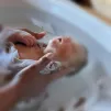 Un bébé apaisée par un bain thérapeutique emmailloté