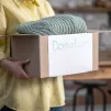 une bénévole tenant un carton plein de vêtements préparés pour le don - @ zinkevych