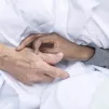 En unité de soins palliatifs, les patients à l'article de la mort sont entourés jusqu'au dernier souffle. Ici, une bénévole tient la main d'un malade de la maison Jeanne Garnier (Paris). ©Corinne Simon / Hans Lucas