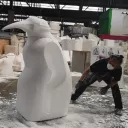 Un ouvrier sculpte le pingouin 