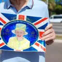 Un niçois tient le drapeau anglais portant la photographie de la reine Elisabeth II sur la Promenade des Anglais à Nice - Photo : RCF Nice Côte d'Azur 