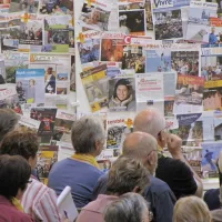 SEDICOM - rédacteurs de journaux paroissiaux en travail devant des unes