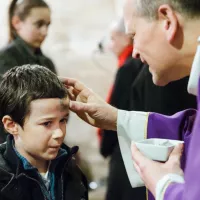 1er mars 2017 : Imposition des cendres sur le front d'un enfant lors de la messe des Cendres, qui marque l'entrée en Carême. Paroisse Saint-Vincent, Le Mesnil-le-Roi (78) France. / ©Guillaume POLI/CIRIC