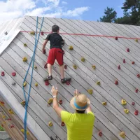 Un jeune écolier, grimpant un mur d'escalade. 