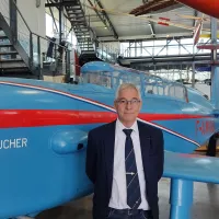 Dominique Montel, chargé de communication de l'Espace Air Passion, pose devant la reconstitution de l'avion Caudron-Rafale d'Hélène Boucher. ©RCF Anjou