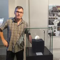 Benoît Mellier, responsable des collections de sciences de la terre du Muséum de sciences naturelles d'Angers, pose avec la fameuse météorite d'Angers ©RCF Anjou