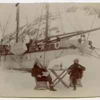 Le bateau "Le Français" est resté prisonnier de la banquise de mars à novembre 1904, sur l’île Wandel, à l’ouest du continent. Ici, le géologue Ernest Gourdon et le photographe Paul Pléneau prennent la pose devant une bouteille de champagne, en attendant que la goélette soit enfin libérée/Ernest Gourdon / courtesy Barbara Caillot Dubus