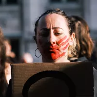 Activiste du collectif #NousToutes, une main rouge dessinée sur le visage pour protester contre les violences sexuelles à l'égard des femmes, Paris, le 12/11/2022 ©Anna Margueritat / Hans Lucas