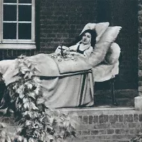 Thérèse effeuillant des roses sur son crucifix. Photographie prise dans le cloître, à la porte de l'infirmerie, le 30 août 1896 ©Wikimédia commons