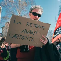 Manifestant à Toulouse avec pancarte “La retraite avant l’arthrite” © Patrick Batard / Hans Lucas