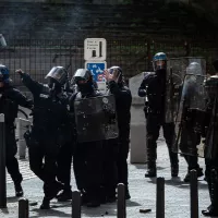 La place est sous les gaz lacrymogène, un policier lance une grenade a main © Stéphane Duprat / Hans Lucas