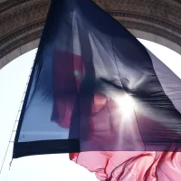 drapeau tricolore sous l'Arc de Triomphe à Paris - © Grégoire Soual-Dubois