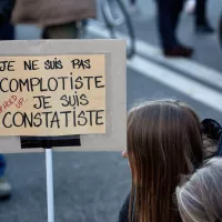 Une manifestante avec une pancarte en assumant ses positions qui sont caractérisées comme complotistes, marche des libertés, Paris, 28 novembre 2020. © Martin Noda / Hans Lucas