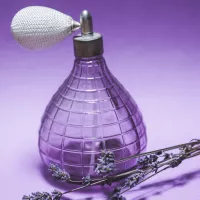 Un flacon de parfum et la célèbre lavande, fleur utilisée pour les huiles essentielles - Photo de Laura Chouette sur Unsplash