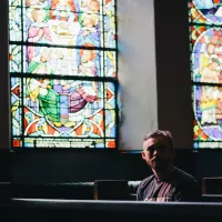 Homme assis dans une église. ©Unsplash