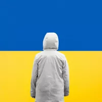 Ukrainien se tenant debout devant le drapeau d'Ukraine. ©Unsplash