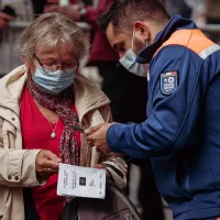 Agent de protection civile vérifiant le passe vaccinal d'individus. ©Unsplash