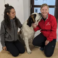 Chiara, soigneuse et Madeleine, chargée de communication, entourent la chienne Replay ©2023 RCF Haute-Savoie