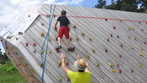 Un jeune écolier, grimpant un mur d'escalade. 