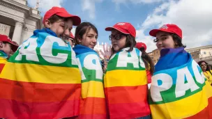 28 mai 2014 : Des jeunes drapés dans le drapeau de la paix attendent la venue du pape François lors de l'audience générale sur la place Saint-Pierre, Vatican ©M.MIGLIORATO/CPP/CIRIC