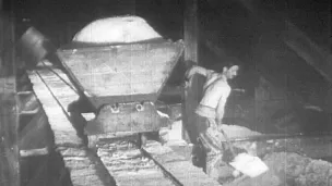 Chargement du sel dans un wagonnet pour le transport du sel au magasin dans une saline franc-comtoise - années 1920-1930 © Musées des techniques et cultures comtoises