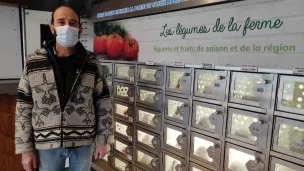 Vincent Popineau, gérant des Légumes de la ferme, devant le distributeur automatique de fruits et légumes. © RCF - Hugo Sastre.