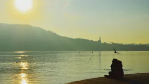 Personne en prière ou méditation devant le lac d'Annecy @SEDICOM