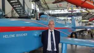 Dominique Montel, chargé de communication de l'Espace Air Passion, pose devant la reconstitution de l'avion Caudron-Rafale d'Hélène Boucher. ©RCF Anjou