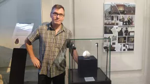 Benoît Mellier, responsable des collections de sciences de la terre du Muséum de sciences naturelles d'Angers, pose avec la fameuse météorite d'Angers ©RCF Anjou