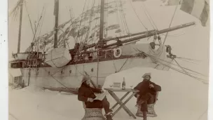 Le bateau "Le Français" est resté prisonnier de la banquise de mars à novembre 1904, sur l’île Wandel, à l’ouest du continent. Ici, le géologue Ernest Gourdon et le photographe Paul Pléneau prennent la pose devant une bouteille de champagne, en attendant que la goélette soit enfin libérée/Ernest Gourdon / courtesy Barbara Caillot Dubus