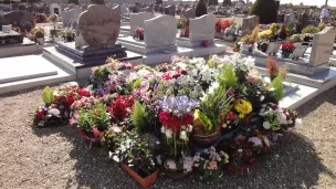 Tombe avec fleurs et couronnes ©wikimedia commons