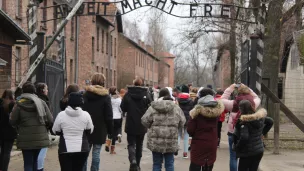 Les collégiens maralpins devant l'entrée du camp de concentration et d'extermination Auschwitz I à Oświęcim en Pologne - Photo RCF