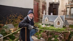 Jean Pouliquen devant la représentation de la chapelle Ste-Anne de Lampaul-Guimiliau. ©Marine Jouannic