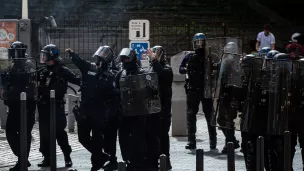 La place est sous les gaz lacrymogène, un policier lance une grenade a main © Stéphane Duprat / Hans Lucas