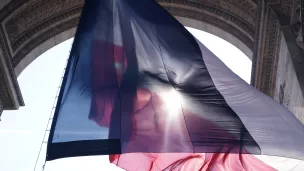 drapeau tricolore sous l'Arc de Triomphe à Paris - © Grégoire Soual-Dubois