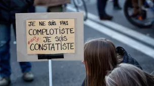 Une manifestante avec une pancarte en assumant ses positions qui sont caractérisées comme complotistes, marche des libertés, Paris, 28 novembre 2020. © Martin Noda / Hans Lucas