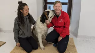 Chiara, soigneuse et Madeleine, chargée de communication, entourent la chienne Replay ©2023 RCF Haute-Savoie