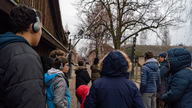 Les collégiens maralpins écoutent la visite du camp de concentration d'Auschwitz I devant l'inscription en allemand «Arbeit macht frei» (Le travail rend libre) - Alejandro Martinez Gonzalez / Collectif DR