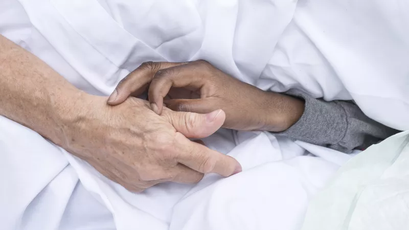 En unité de soins palliatifs, les patients à l'article de la mort sont entourés jusqu'au dernier souffle. Ici, une bénévole tient la main d'un malade de la maison Jeanne Garnier (Paris). ©Corinne Simon / Hans Lucas