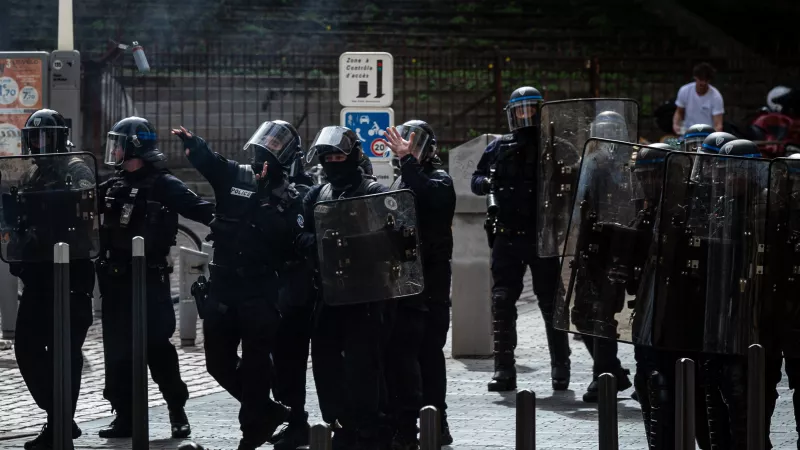 La place est sous les gaz lacrymogène, un policier lance une grenade a main © Stéphane Duprat / Hans Lucas