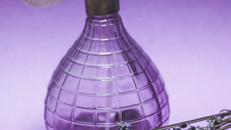 Un flacon de parfum et la célèbre lavande, fleur utilisée pour les huiles essentielles - Photo de Laura Chouette sur Unsplash