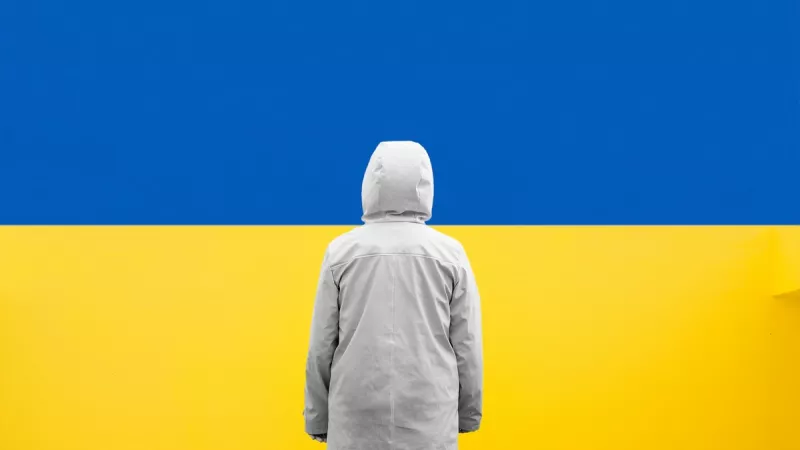 Ukrainien se tenant debout devant le drapeau d'Ukraine. ©Unsplash