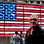 DR - Serge July devant un drapeau américain