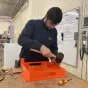 Pasha, en deuxième année à l'école de production, peaufine un réhausse-assiette. © RCF Sud Bretagne