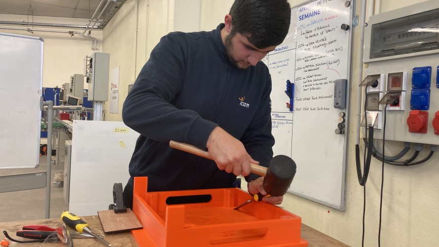 Pasha, en deuxième année à l'école de production, peaufine un réhausse-assiette. © RCF Sud Bretagne
