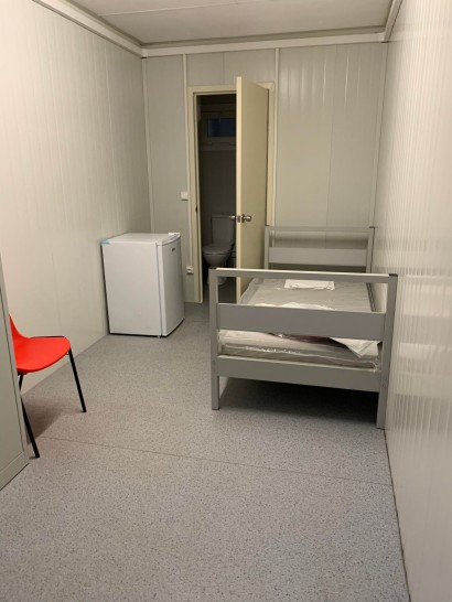 Dans un algeco, un petit frigo, des toilettes, un lit et une armoire. ©Milan Tinnirello / RCF